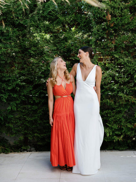 Bride posing with wedding guest at Island Resort, elegant Athens wedding celebration on the Athenian Riviera.