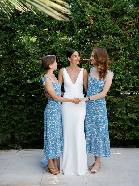 Bride with bridesmaids in blue dresses at Island Resort, chic Athens Riviera destination wedding.