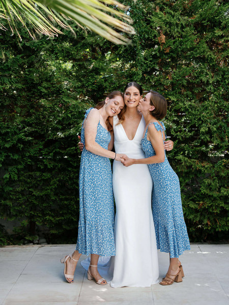 Bridesmaids embracing the bride at Island Resort, joyful Athens wedding on the Athenian Riviera.