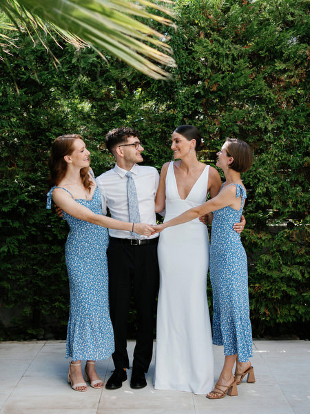 Bride and wedding party holding hands at Island Resort, stylish Athens Riviera wedding celebration in Greece.