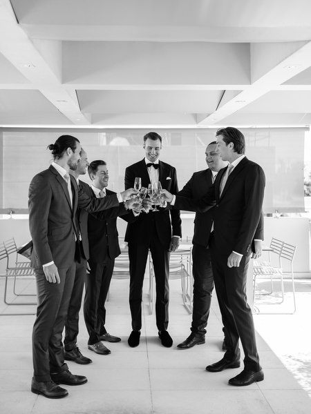 Groomsmen raising a toast before the ceremony at Island Resort, luxury Athens destination wedding in Greece.