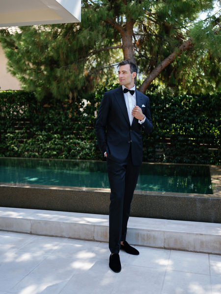 Full-length groom portrait at Island Resort, black-tie Athens Riviera wedding in Greece.