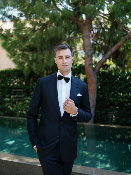 Groom standing by the pool at Island Resort, elegant destination wedding in Athens, Greece.