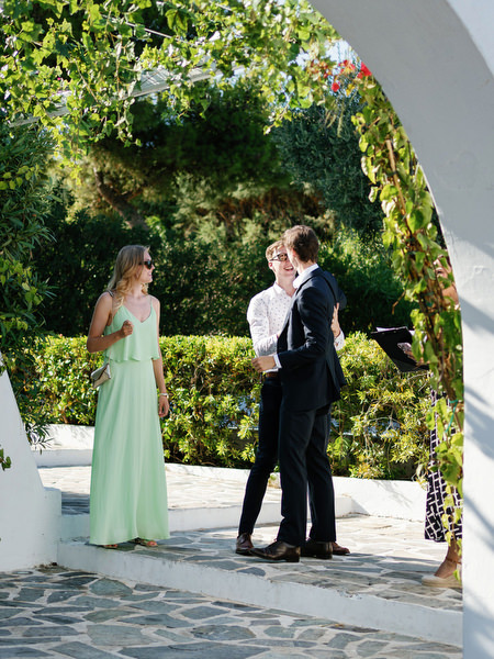 Guests mingling beneath vine-covered archways at Island Resort, stylish destination wedding in Athens, Greece.