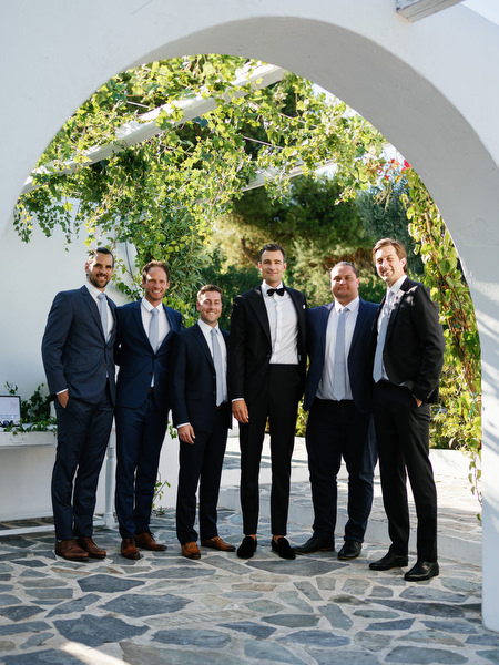 Guests posing under Mediterranean arches at Island Resort, luxury Athens destination wedding venue.