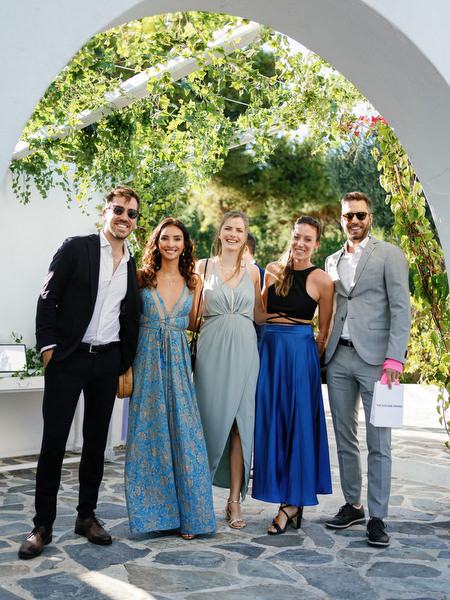 Friends posing beneath white arches at Island Resort, luxury wedding venue on the Athens Riviera.