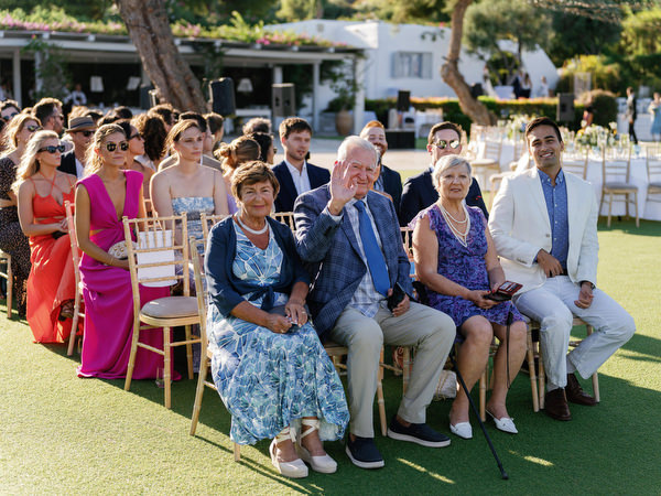 Wedding guests seated on the ceremony lawn at Island Resort, seaside Athens Riviera wedding in Greece.