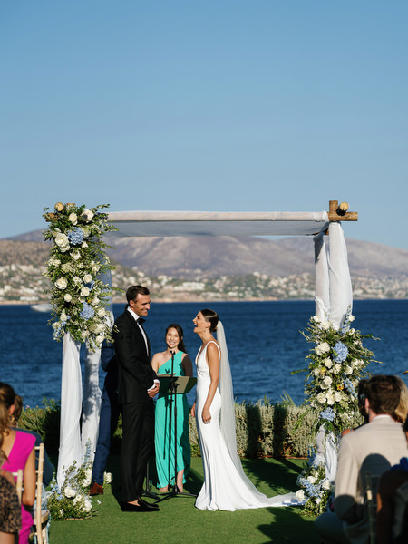 Jewish wedding ceremony under floral chuppah at Island Resort overlooking the Aegean Sea, Athens Riviera wedding venue.