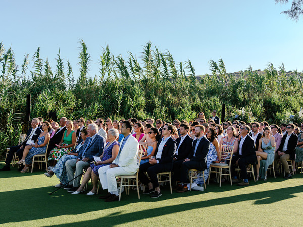 Jewish wedding ceremony under floral chuppah at Island Resort overlooking the Aegean Sea, Athens Riviera wedding venue.