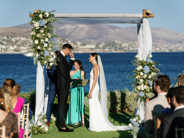 Emotional moment during vows at Island Resort, romantic Athens Riviera seaside wedding in Greece.