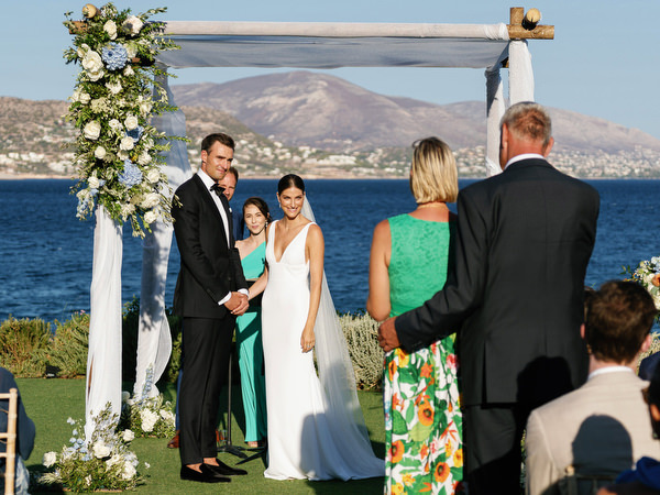 Family members approaching the chuppah at Island Resort, meaningful Athens Riviera wedding ceremony.