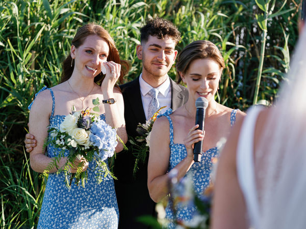 Bridesmaids giving speech during ceremony at Island Resort, Athens Riviera destination wedding in Greece.