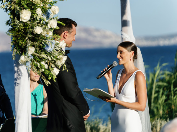 Bride speaking during seaside ceremony at Island Resort, elegant Athens wedding on the Athenian Riviera.
