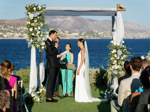 Intimate vow exchange at Island Resort, luxury Jewish wedding in Athens overlooking the sea.