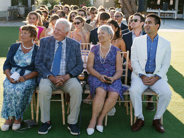 Wedding guests reacting during ceremony at Island Resort, elegant Athens wedding on the Athenian Riviera.