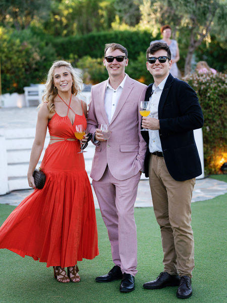 Stylish wedding guests at Island Resort during Athens Riviera cocktail hour celebration.
