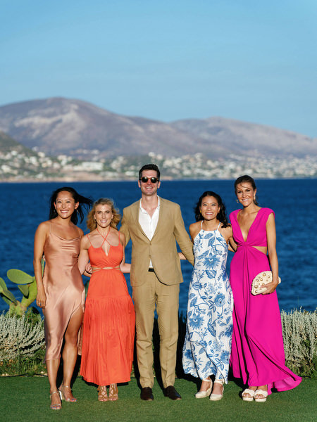 Guests posing with Aegean Sea backdrop at Island Resort, elegant Athens Riviera destination wedding.