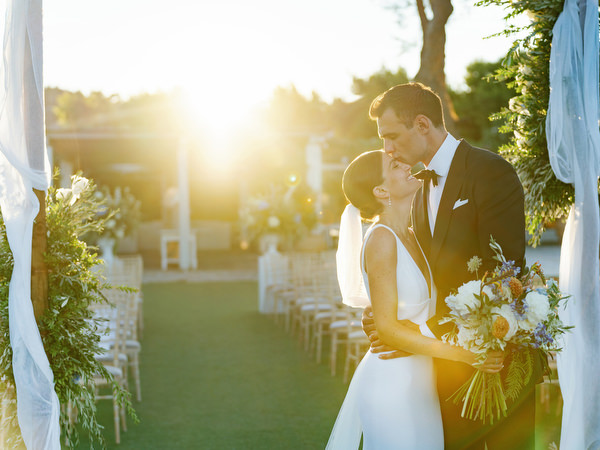 Bride and groom in golden hour light at Island Resort, romantic Athens Riviera sunset wedding.