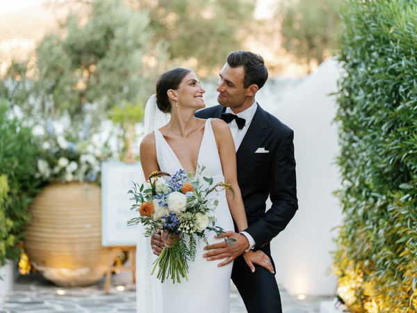 Bride and groom sharing intimate moment at Island Resort, elegant Athens Riviera wedding celebration.