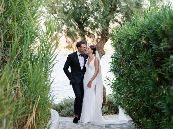Bride and groom walking through garden pathways at Island Resort, luxury wedding on the Athens Riviera.