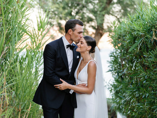 Bride and groom walking through garden pathways at Island Resort, luxury wedding on the Athens Riviera.