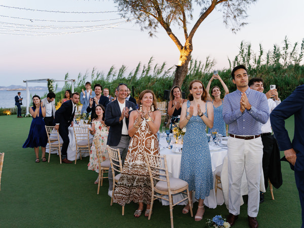 Guests cheering at Island Resort wedding reception, vibrant Athens Riviera celebration in Greece.