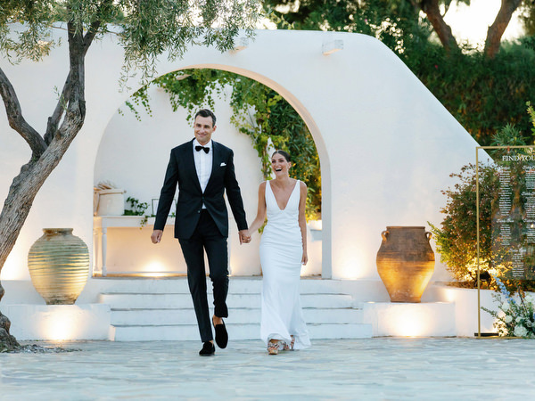 Bride and groom entering reception at Island Resort, romantic Athens Riviera wedding celebration.