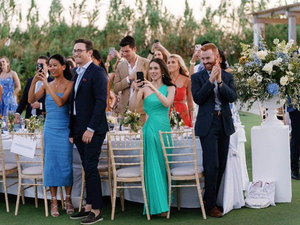 Wedding guests applauding during reception at Island Resort, lively Athens Riviera wedding celebration in Greece.
