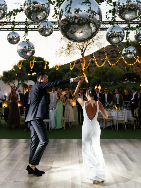 First dance at Island Resort under disco balls, luxury Athens Riviera seaside wedding reception.