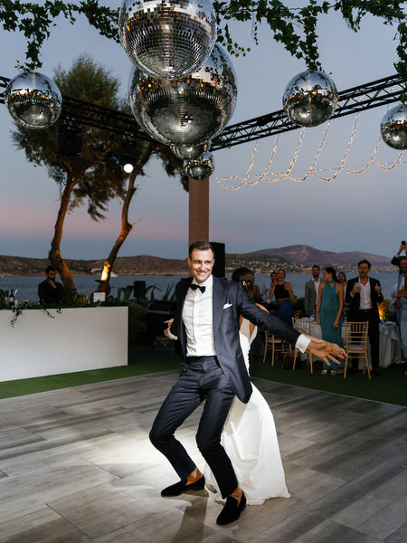 Couple dancing under disco balls at Island Resort, vibrant Athens Riviera wedding reception party.