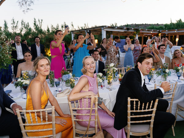 Wedding guests cheering during reception at Island Resort, luxury Athens Riviera seaside wedding.