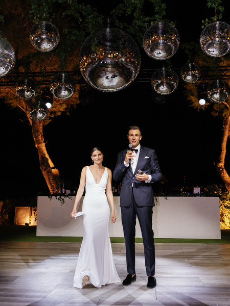 Bride and groom under disco balls at Island Resort, iconic Athens Riviera wedding party.