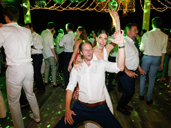 Guests dancing at night at Island Resort, vibrant Athens Riviera seaside wedding reception.