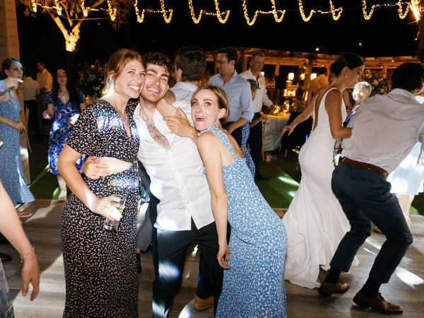 Guests dancing at Island Resort wedding reception, lively Athens Riviera seaside celebration.