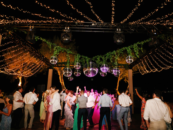 Full dance floor under string lights at Island Resort, iconic Athens Riviera wedding reception.