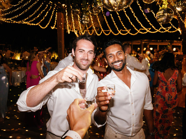 Guests celebrating with drinks at Island Resort, luxury Athens Riviera destination wedding party.