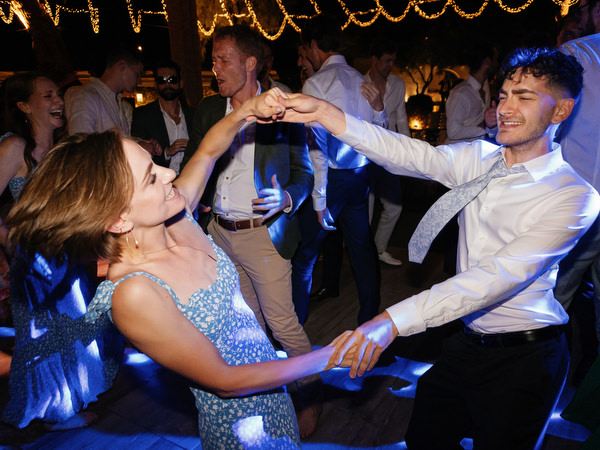Guests dancing at Island Resort wedding reception, lively Athens Riviera seaside celebration.