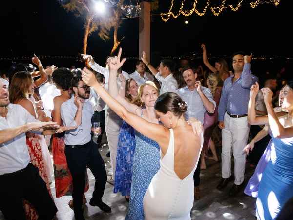 Bride dancing at Island Resort wedding reception, lively Athens Riviera seaside celebration.