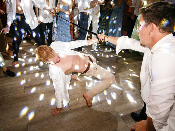 Guest dancing energetically at Island Resort, lively Athens Riviera seaside wedding party.