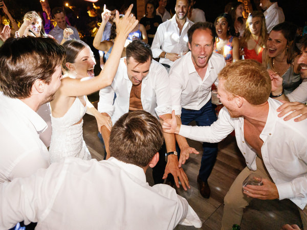Groom celebrating with friends at Island Resort, high-energy Athens Riviera destination wedding.