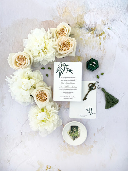 Elegant wedding invitation flat lay with ivory florals at Anassa Hotel Cyprus wedding.