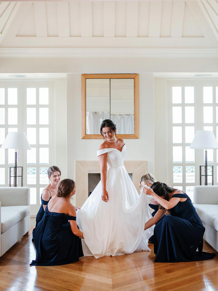Bridesmaids helping bride with gown before ceremony at Anassa Hotel Cyprus wedding.