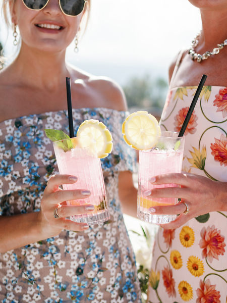 Guests holding pink summer cocktails at Anassa Hotel destination wedding in Cyprus.