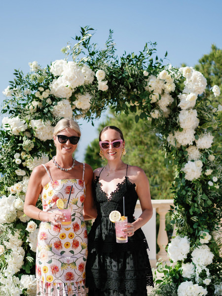 Guests in colorful summer dresses at Anassa Hotel coastal wedding in Cyprus.