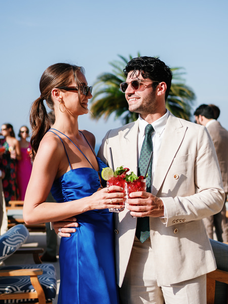 Wedding guests holding cocktails at Mediterranean luxury wedding in Cyprus.