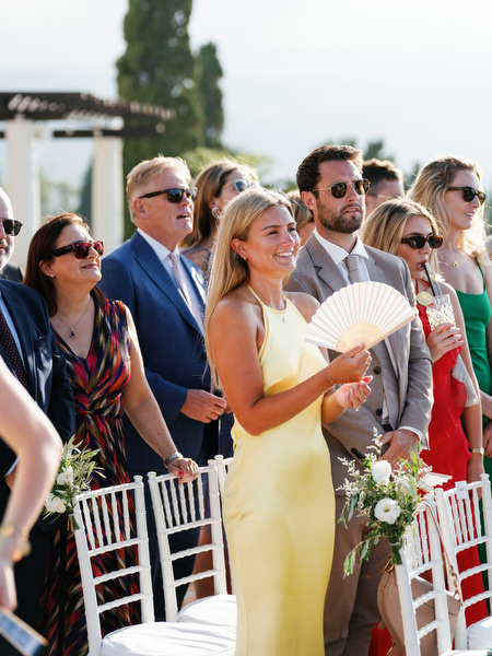 Wedding guests watching bride arrive at Anassa Hotel sea view ceremony.