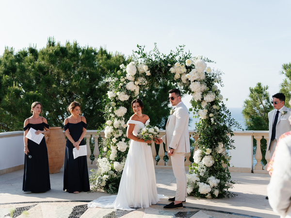 Bridesmaids standing beside couple during ceremony at Anassa Hotel wedding.