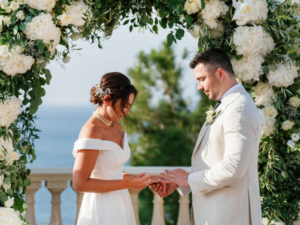 Bride and groom exchanging rings during ceremony at Anassa Hotel Cyprus.