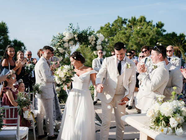 Bride and groom walking down aisle after ceremony at Anassa Hotel Cyprus wedding.