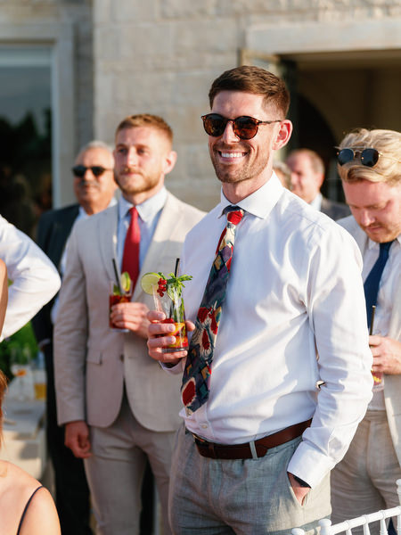 Guests listening to wedding speech at Anassa Hotel terrace reception.